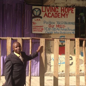 Pastor Lawrence pictured outside the structure that houses both the school and his church - he started construction on this structure 3 months ago. 